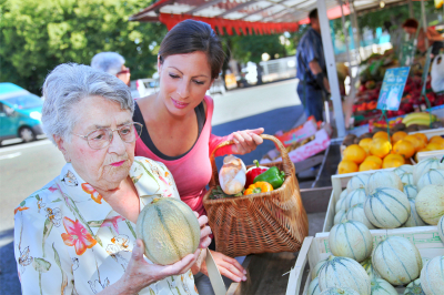 young lady helping senior woman on grocery